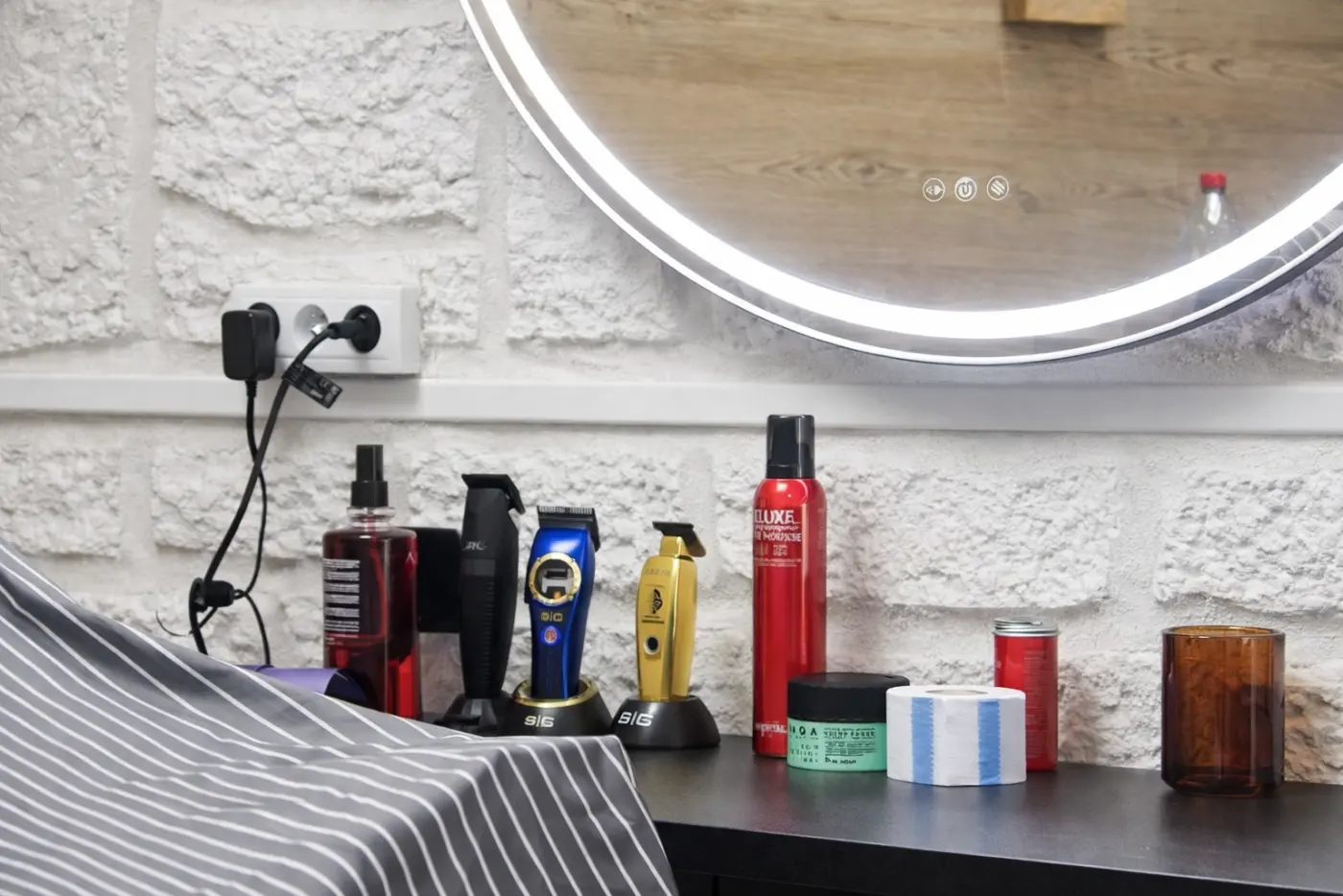 Poste Eleganze avec miroir rond, tondeuses et produits prêts pour le service